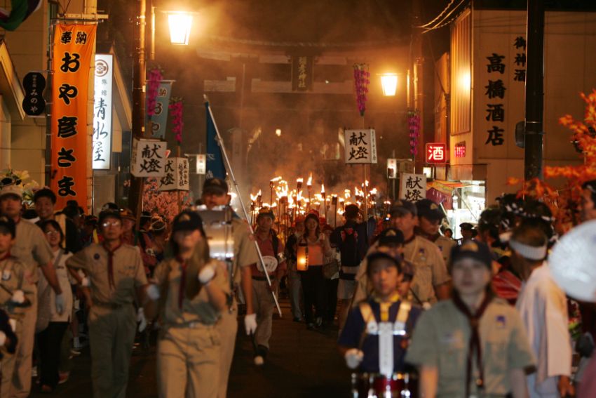 御神火が到着し、一の鳥居から巡行が始まります。左端にちらりとみのやの看板も見えますね。